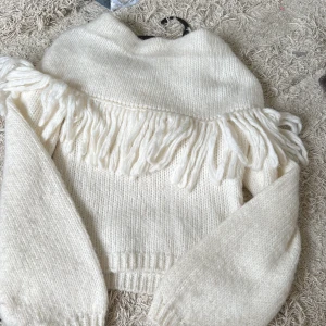 Vit stickad tröja med fransar Lindex XS - Supermysig vit stickad tröja från Lindex i storlek XS. Tröjan har långa ärmar och coola fransdetaljer över bröstet och axlarna. Perfekt för dig som vill ha en unik och trendig look med lite western-vibe. Original pris 499