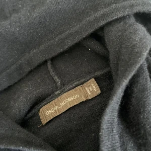 Marinblå Kashmir/merinoull Oscar Jacobson hoodie - Svart hoodie från Oscar Jacobson i mjuk kashmir👍🏼🎉Klassisk modell med huva och långa ärmar, perfekt för dig som gillar stilren och bekväm look. Den har också en liten defekt i armhålan. Passar dig som vill ha en hoodie med exklusiv känsla och enkel design.🎉👍🏼