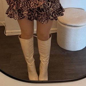 Höga stövlar med klack - Beiga stövlar med hög klack och fyrkantig tå och brett skaft. 