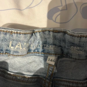 Ljusblå jeansbyxor från L.A. Potential - 146-Säljer ett par ljusblå jeansbyxor från L.A. Potential i storlek 146. Klassisk femficksmodell med knapp och dragkedja framtill samt läderpatch bak i midjan. Perfekta för dig som gillar en tidlös jeanslook.