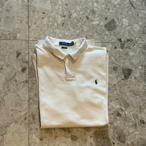 Vit pikétröja från Polo Ralph Lauren - Klassisk vit pikétröja från Polo Ralph Lauren. En ett väldigt bra val för sommaren. Nypriset på denna ligger på cirka 1600kr så ett väldigt bra pris😊