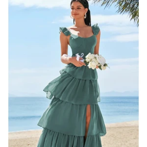 Vinröd volangklänning med axelband - Säljer en vinröd klänning med volangdetaljer och smala axelband. Klänningen har markerad byst, volanger i kjolen och en feminin siluett. Perfekt för dig som vill sticka ut med en färgstark och romantisk look. Nypris 1132