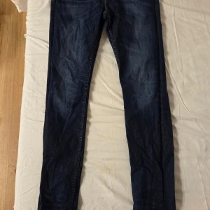 Mörkblå jeans från Lee x Carlings - Säljer ett par mörkblå jeans från Lee x Carlings. Klassisk femficksmodell med raka ben och normal passform. Jeansen har snygga kontrastsömmar och är tillverkade i slitstarkt denimtyg. Perfekta till vardags och enkla att matcha.
