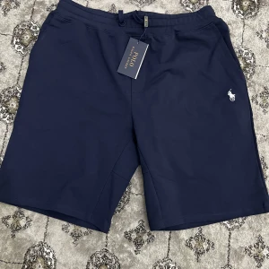 Mörkblå shorts Polo - Säljer dessa polo shorts eftersom den passar inte mig. Det står storlek S men den är större än vad den är. Längden är 51 cm och bredden 41 cm. Jag skulle noga säga det skulle passa någon M-L beroende på vikt och längd. Den me helt nya oanvänd