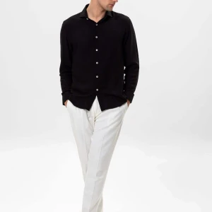 Svart Linneskjorta - Stilren svart linneskjorta med klassisk krage och vita knappar framtill. Skjortan har lång ärm och en rak passform som passar till många olika tillfällen. Märket är Antioch och har kvitto.