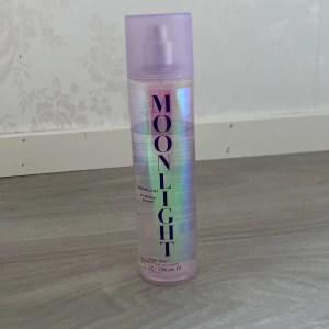 Moonlight Body Mist från Ariana Grande - Moonlight Body Mist från Ariana Grande i en skimrande, iriserande flaska med lila lock. Doften är fräsch och feminin, perfekt för dig som gillar kändisparfymer. Flaskan rymmer 236 ml och har en modern, stilren design.