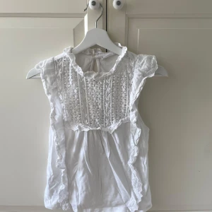 Vit blus med spets och volang från MNG - Söt vit blus från mango med spetsdetaljer framtill och volanger längs axlarna. Perfekt för sommaren💗