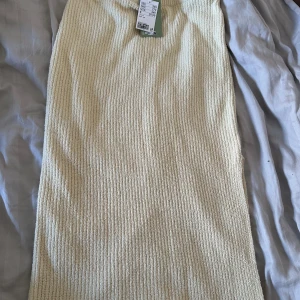 Beige ribbad kjol från hm - Säljer en beige ribbad kjol från HM. Kjolen har en rak passform och är tillverkad i ett mjukt, stickat material. Perfekt för dig som gillar en enkel men trendig stil. Prislapp och aldrig använd