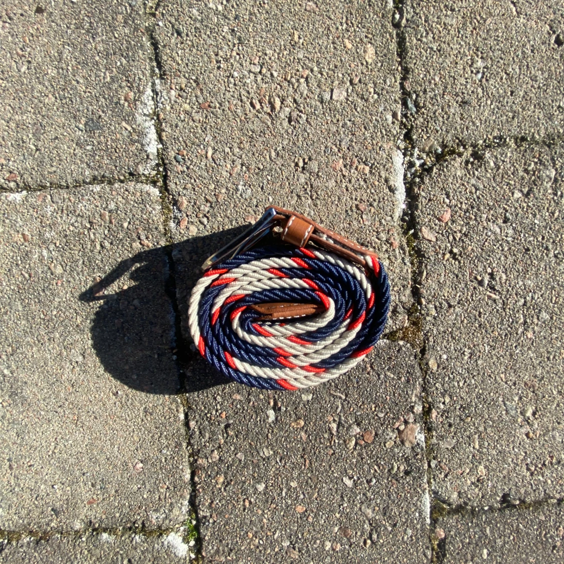 Randigt bälte med läderdetaljer