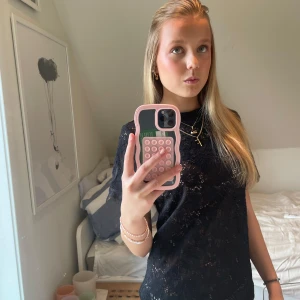 Svart spetsblus från Gina Tricot - Snygg svart spetsblus från Gina Tricot med korta ärmar och ett elegant mönster. Blusen har en normal passform och är tillverkad i ett lätt och luftigt material.