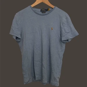 Ralph Lauren - Snygg blå t-shirt från Polo Ralph Lauren med en liten broderad logga på bröstet. Perfekt för en avslappnad stil. Tillverkad i mjukt material för extra komfort.