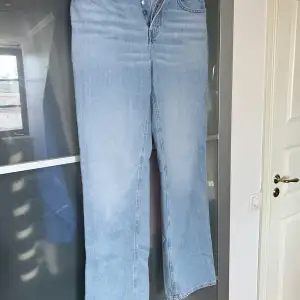 Snygga ljusblå jeans med hög midja och knäppning fram. Klassisk femficksdesign och raka ben för en tidlös look. Perfekta för en avslappnad stil.
