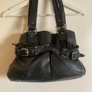 Väska - Supersnygg exklusiv svart handväska i skinn från märket Vezzano med silver detaljer. Vintage, sparsamt använd och i toppenskick.  Tar emot bud!😊😊