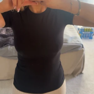 Svart topp - Säljer denna svarta tshirt ifrån Intimissimi som är köpt på Zalando i storlek S. Den funkar till allt och alla outfits + att den är väldigt mjuk och skön!                                                          Säljer den eftersom  den inte kommer till användning då jag har många likadana t-shirts. Ord pris: 269kr