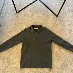 Gråblå tröja med dragkedja från Samsøe Samsøe - Snygg grå tröja från Samsøe Samsøe med dragkedja och krage. Perfekt för en stilren look. Tröjan har långa ärmar och är tillverkad i ett mjukt material.