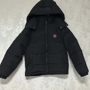 Trapstar jacka  - Jag har en jacka till salu, och jag tror att du kommer att älska den! Den är svart med röda detaljer och passar perfekt för storlekar S och M. Om du är intresserad, tveka inte att höra av dig så kan vi diskutera pris och detaljer. säljer pga för liten. Missa inte chansen att få denna stiliga jacka nu!