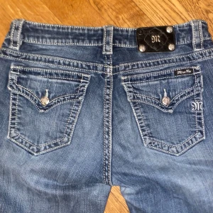 Blå jeans från Miss Me - Snygga blå jeans från Miss Me med dekorativa bakfickor och knappar. De är bootcut och midwaist, men sitter som lowwaist. En liten lagning på innre låret som inte syns när man har de på. Säljer de för att de är lite stora för mig☺️(Jag är ca 167 och de är lite långa för mig)