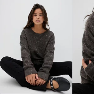 Mörkgrå glittrig tröja med öppen rygg - Säljer en snygg mörkgrå tröja med glittriga detaljer och en trendig öppen rygg. Tröjan har långa ärmar och en bekväm passform. Perfekt för att lägga till lite glitter i vardagen! ✨