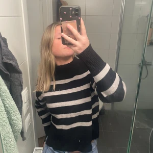 Svart och vit/grå randig tröja  - Säljer en svart och vit/grå randig tröja från Ullared Tröjan har långa ärmar och en ribbad kant vid halsen och nederkanten. Perfekt för en stilren och bekväm look. 🖤🤍 går att pruta 