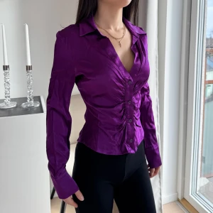 Lila blus med knappar - Snygg lila blus med figurnära passform. Köpt från Zara, strl XS. Använd 2 gånger.