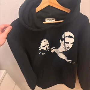 Saint Laurent hoodie - Tja! Säljer denna tvärfeta saint Laurent hoodie i strl L. Hoodien är i utmärkt skick, finns inga skador eller defekter, dessutom försiktigt använd. Hoodien är svart och självklart äkta. Hör av er vid frågor eller funderingar! 