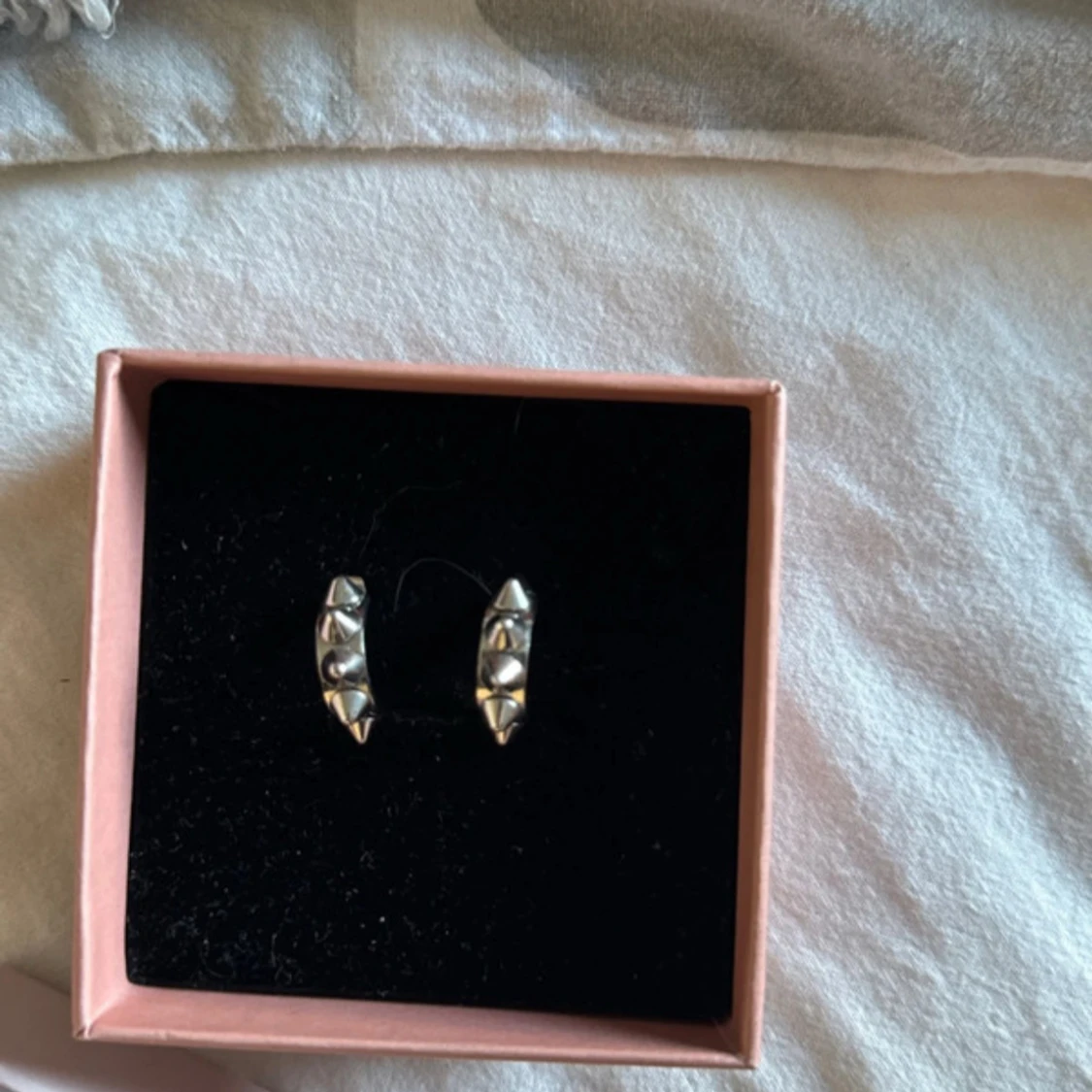 Silvriga örhängen med nitar från Edblad