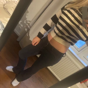 Randig stickad tröja - Säljer en snygg randig tröja med svart och beiga ränder. Tröjan har långa ärmar, perfekt för en trendig look. Den är väldigt mjuk och absolut inte stickig💗