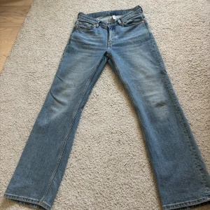 Blå jeans från Weekday  - Säljer ett par klassiska blå jeans från weekday. De har en bootcut passform och är knappt använda så därför ett väldigt bra skick. De ör även i modellen TWIG 