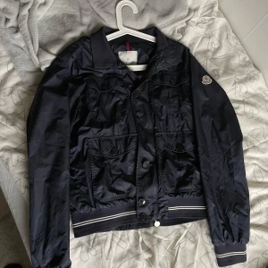 Moncler field jacket - Först till kvarn! Säljer för 1000 kr vid köp via Swish direkt sen postar jag via plik!!🔥🔥Snygg marinblå jacka från Moncler med knappar och ribbade detaljer. Jackan har långa ärmar och flera fickor framtill. Perfekt för en stilren look. Legitcheckad på highend Sweden på Facebook🔥
