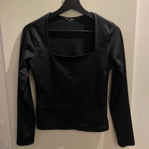 Svart långärmad topp - Snygg svart långärmad topp med fyrkantig urringning. Perfekt för en stilren look. Passar bra till både jeans och kjol.