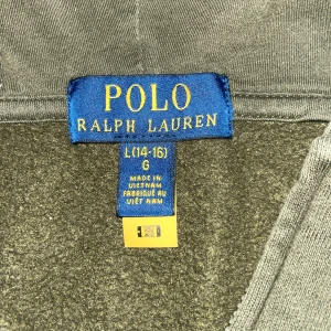 Olivgrön zip hoodie från Polo Ralph Lauren - Säljer en olivgrön zip hoodie från Polo Ralph Lauren i storlek 14-16 Tröjan har dragkedja framtill, huva och två fickor. Klassisk broderad logga på bröstet. Perfekt för en avslappnad stil.