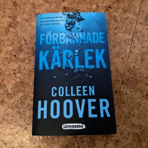 Förbannade kärlek - Säljer boken 'Förbannade kärlek' av Colleen Hoover. Omslaget är blått med undervattensmotiv och stora, tydliga bokstäver. Perfekt för dig som gillar romantik och drama. Svensk utgåva från Lovereads.