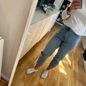 Ljusblå jeans med hål på knät från SHEIN - Säljer ett par ljusblå jeans från SHEIN i modellen Petite XXS. Jeansen har hög midja, raka ben och ett hål på ena knät för en trendig look. Perfekta för dig som gillar en avslappnad stil.
