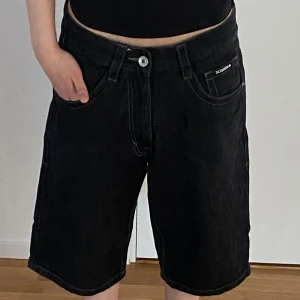 Svarta jeansshorts från Avirex - Svarta jeansshorts från Avirex med passform. Tillverkade i för en skön känslan