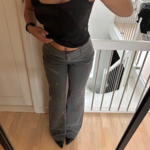 Gråa lågmidjade kostymbyxor  - Så snygga gråa lågmidjade kostymbyxor från weekday! (Säljer även ett par likadana bruna, annons finns i min profil). Jag är 164 ungefär och dessa är perfekt längd med klackar. Jag brukar ha storlek 36 på byxor men tog dessa i 38 så de skulle vara lagom långa med klackar, men själva storleken upplevs densamma! Knäpps med dragkedja och knapp om man vill. Prislapp kvar, köpt för 599. ❤️