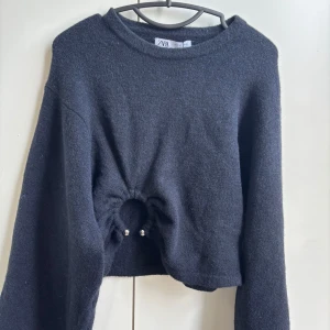 Blå croppad tröja från Zara med ringdetalj - Trendig blå croppad tröja från Zara med lång ärm och unik ringdetalj framtill. Mjuk och lite fluffig känsla, perfekt till jeans eller kjol. Desssutom helt oanvänd och pris kan diskuteras! 