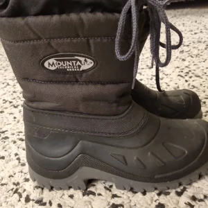 Svarta vinterstövlar från Mountain - Säljer ett par svarta vinterstövlar från Mountain med grov sula och snörning upptill. Insidan är fodrad med mjuk och varm fleece. Perfekta för kalla dagar och snöiga promenader.