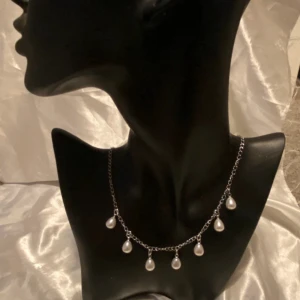 Silverfärgat halsband med pärldroppar - Ett elegant silverfärgat halsband med sju hängande droppformade pärlor. Kedjan är tunn och smidig, tillverkat i rostfritt stål! Kika in min profil för andra smycken💞
