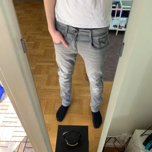 Grå replay jeans - Ett par grå jeans från märket replay, jeansen är i mycket bra skick förutom att ”backtaggen’ på jeansen är borta (se bild 3). Denna defekt påverkar däremot inte användningen av jeansen. Modellen är slim fit och det är replay Anbass med hyperflex 