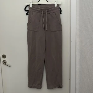 Beige mjukisbyxor med snörning - Säljer ett par bekväma beige mjukisbyxor med elastisk midja och snörning. Byxorna har praktiska fickor fram och bak, perfekta för en avslappnad stil. Passar utmärkt för mysiga dagar hemma eller en avslappnad promenad.