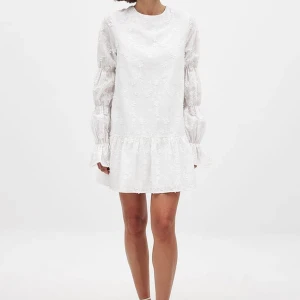 Studentklänning  - Vit klänning med blommigt mönster. Den har långa ärmar och en elegant öppen rygg med knytband. Perfekt som student- eller midsommarklänning. Den är aldrig använd med prislappen kvar💘