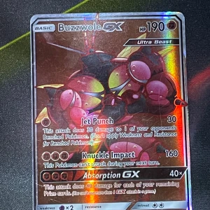 Buzzwole GX Pokémonkort (inte äkta) - Säljer ett fejk Buzzwole GX Pokémonkort med 190 HP. Kortet har attacker som Jet Punch, Knuckle Impact och Absorption GX. Det är en Ultra Beast med en cool design och holografisk yta. Perfekt för samlare eller spelare som vill förstärka sin kortlek.