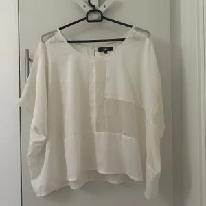 Vit blus från Bikbok - Säljer en stilren vit blus från bikbok med lös passform. Blusen har korta ärmar och en rund halsringning. Perfekt för en avslappnad och elegant look.