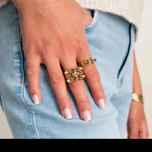 Guldfärgad ring med nitar - Snygg guldfärgad ring dekorerad med små nitar. Perfekt för att ge din outfit en edgy touch. Passar bra till både vardag och fest. 17.5 mm