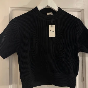 Svart ribbad topp från Beymen Club - Svart ribbad topp från Beymen Club med korta ärmar. Toppen har en rund halsringning och är tillverkad i ett bekvämt material. Oanvänd, med etiketter på! Toppen är en storlek S, men liten i storleken. 