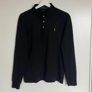 Ralph Lauren pikétröja - Ralph Lauren svart långärmad pikétröja. Storlek M. I jätte bra skick utan defekt. Skickar alltid samma eller nästa dag. Skriv ifall du undrar om något mer. 