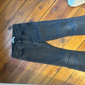 Svarta jeansbyxor med knappar - Snygga svarta jeansbyxor med knappgylf och klassisk femficksdesign. Perfekta för en avslappnad stil. Passar bra till både t-shirt och skjorta. Storlek 140