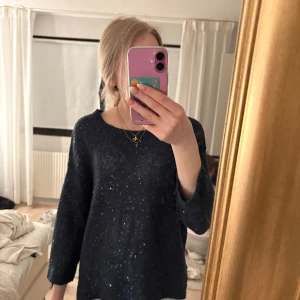  glittrig tröja med öppen rygg - Säljer en marinblå glittrig tröja med öppen rygg. Tröjan har långa ärmar och har paljetter.