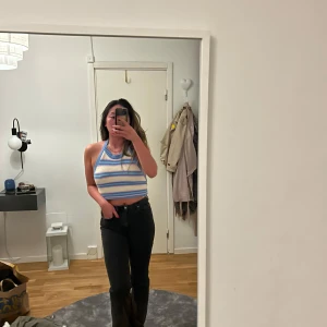 Randig ärmlös topp - Säljer en snygg ärmlös topp med blå och vita ränder. Toppen har en halterneck-design från Zara i M