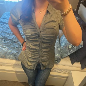 Grågrön vintage kortärmad blus från Fransa! - Säljer en superfin grågrön blus från Fransa med korta ärmar och knappar framtill. Blusen har en smickrande rynkad design som ger en fin passform. Inga defekter och superbra skick! Pris går alltid att diskutera 💕💕